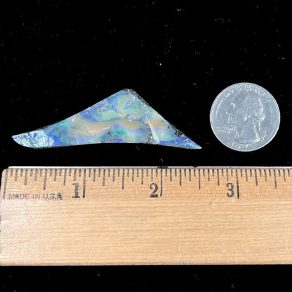 A loose, triangular shaped boulder opal stone from Queensland, Australia.