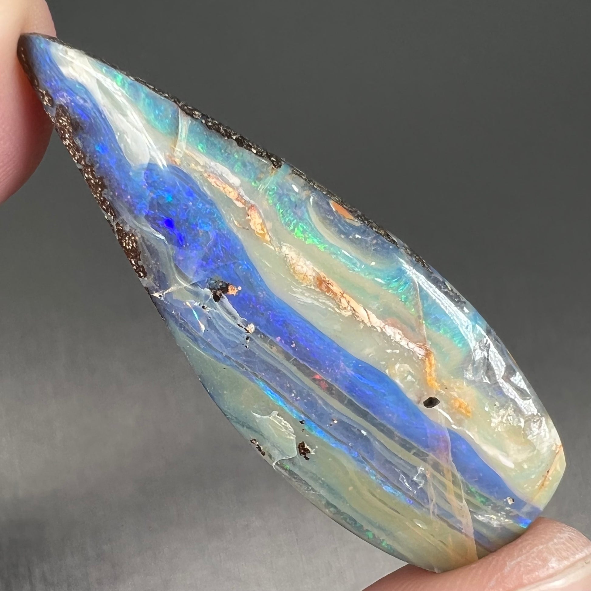 A loose, pear shaped boulder opal stone from Queensland, Australia.