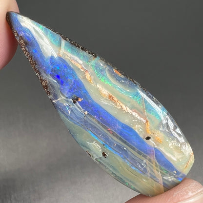 A loose, pear shaped boulder opal stone from Queensland, Australia.
