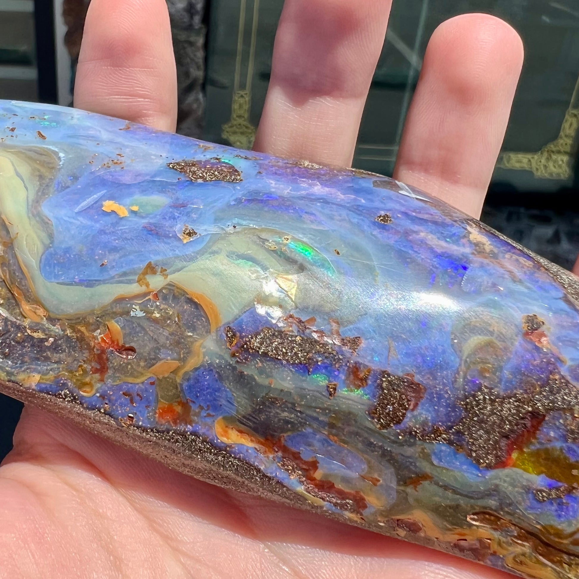 A 7 inch long polished blue Quilpie boulder opal specimen from Queensland, Australia.