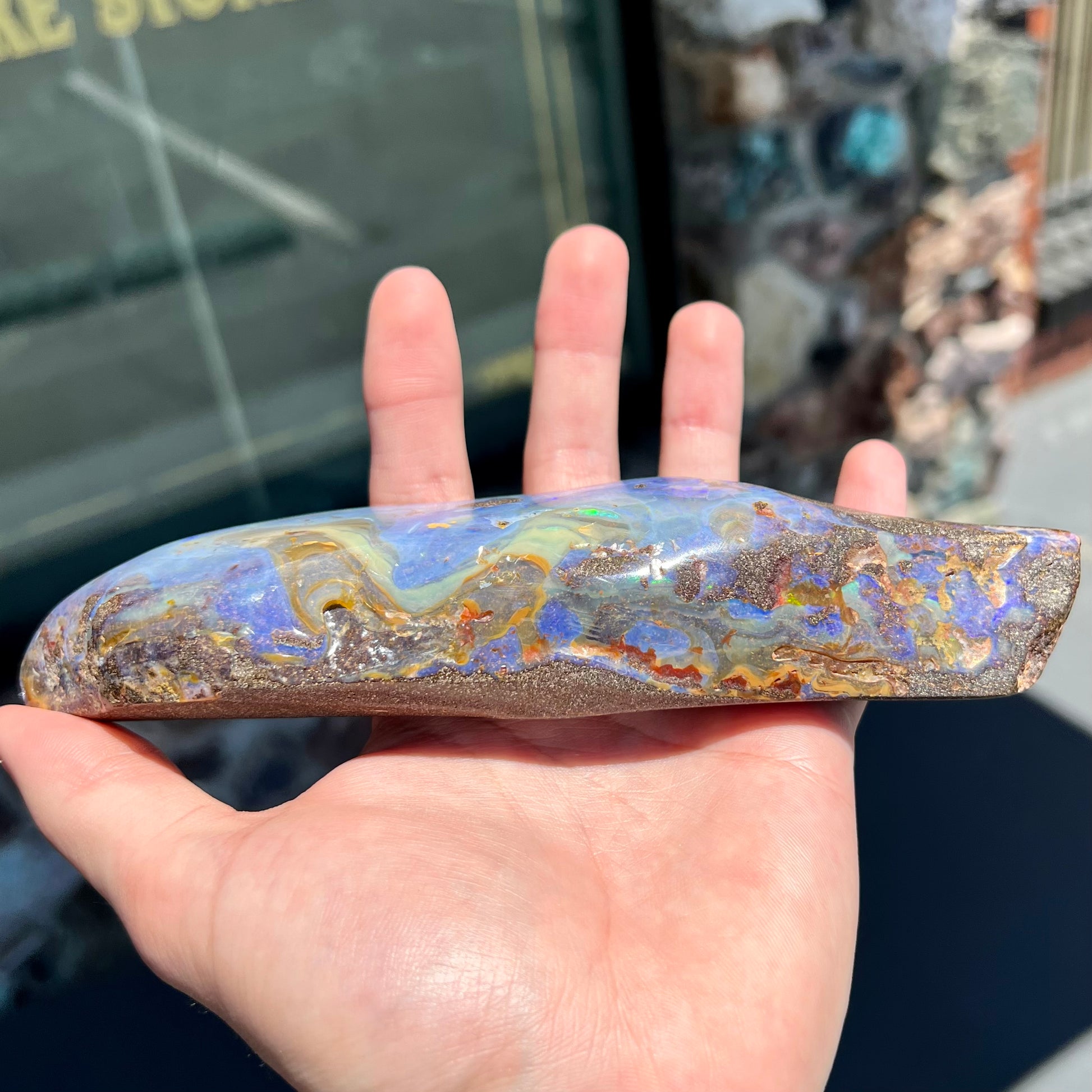 A 7 inch long polished blue Quilpie boulder opal specimen from Queensland, Australia.