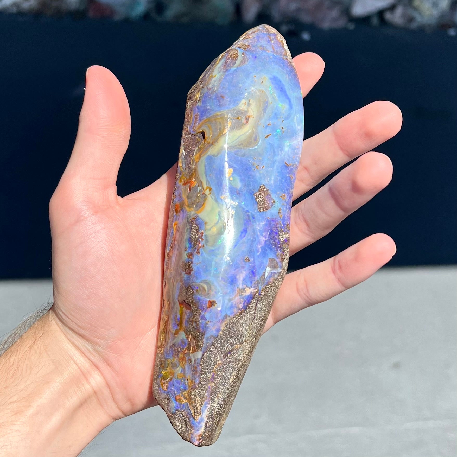 A 7 inch long polished blue Quilpie boulder opal specimen from Queensland, Australia.
