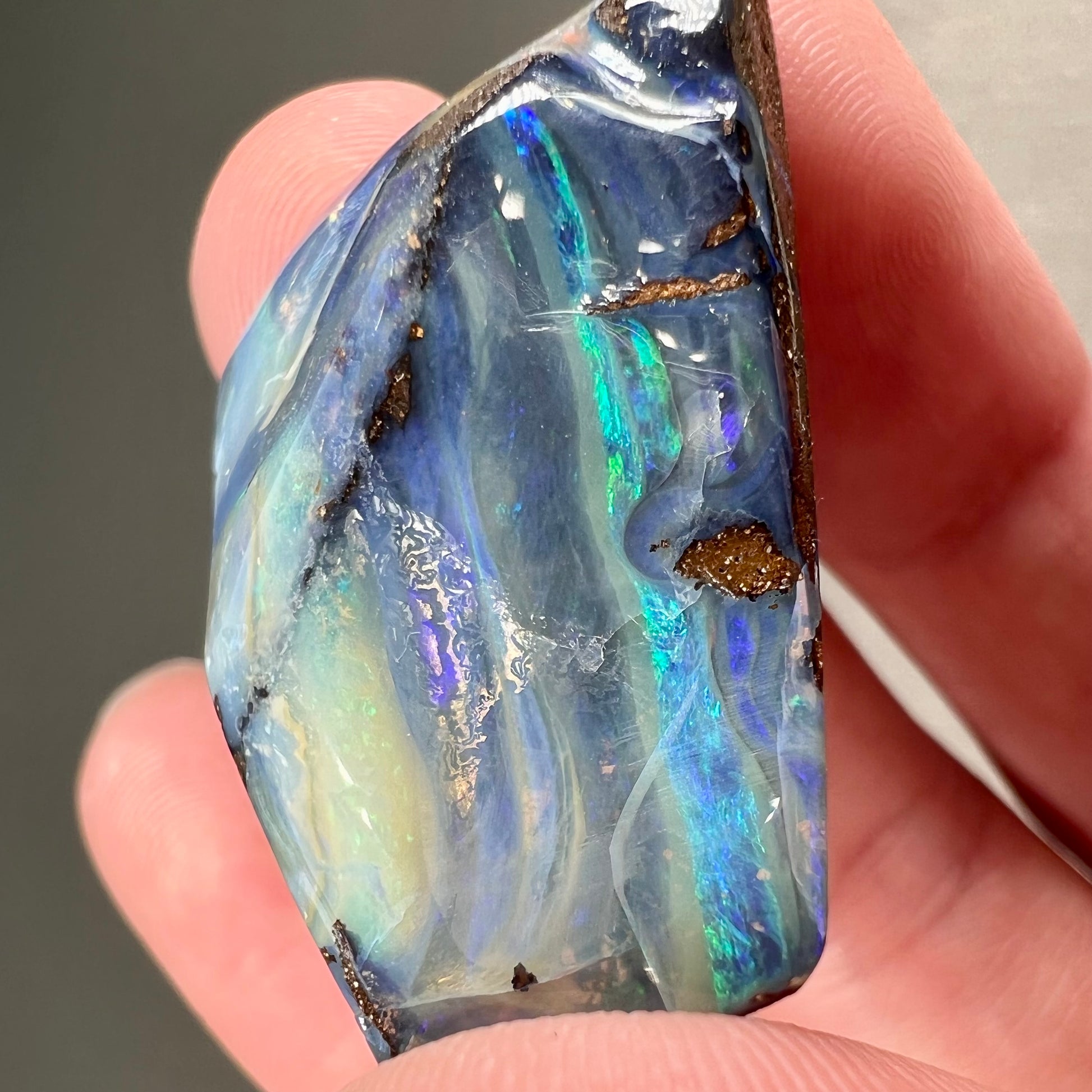 A loose, polished blue boulder opal specimen from Queensland, Australia.