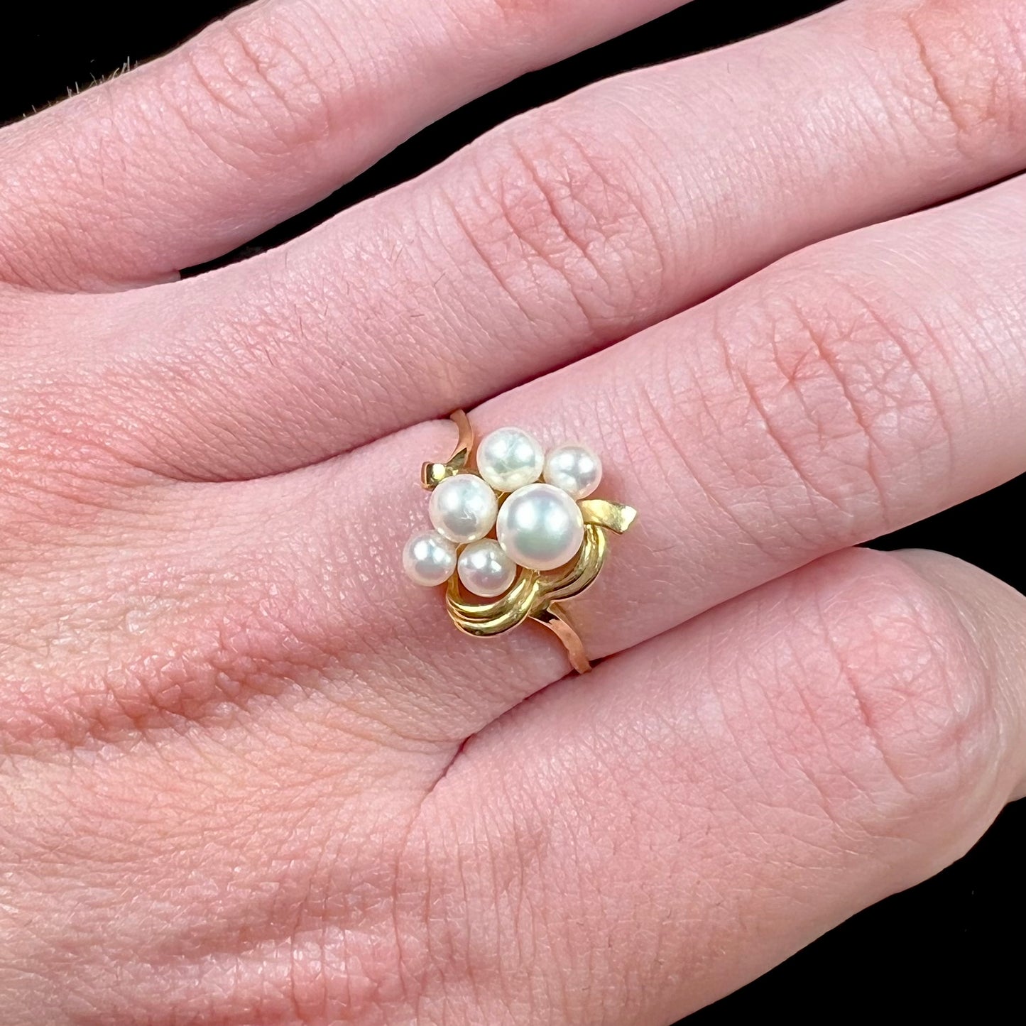 A yellow gold Akoya pearl cluster ring.  The pearls are round with pink overtones and resemble bubbles.