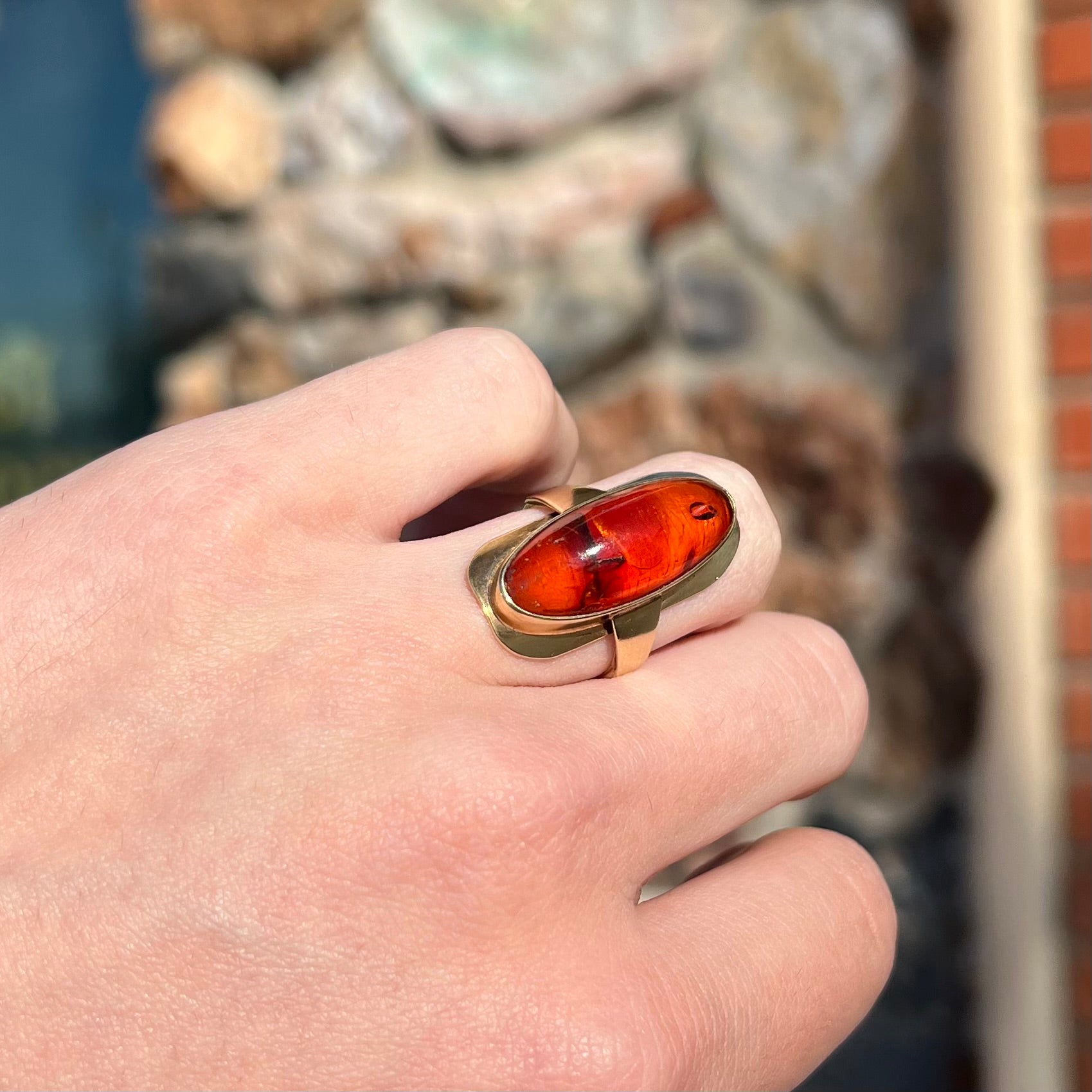 An oval cabochon cut Baltic amber stone set in a yellow gold ring and stamped "AMBER GUILD."