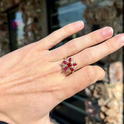 A yellow gold cluster ring set with pigeon blood red Burma rubies and diamonds.