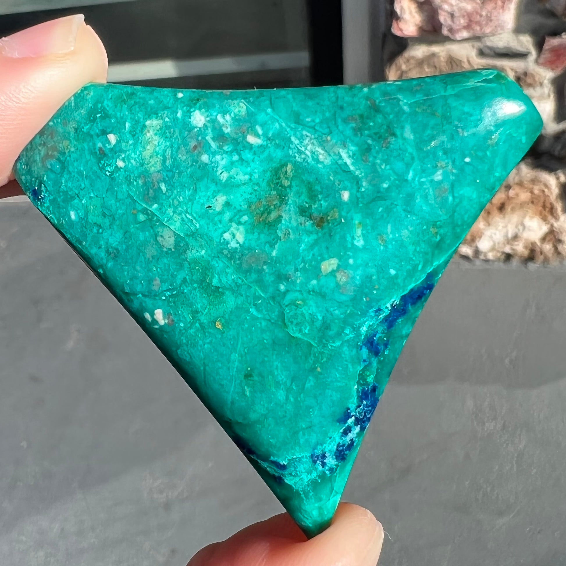 Loose polished green chrysocolla stone with blue azurite inclusions.