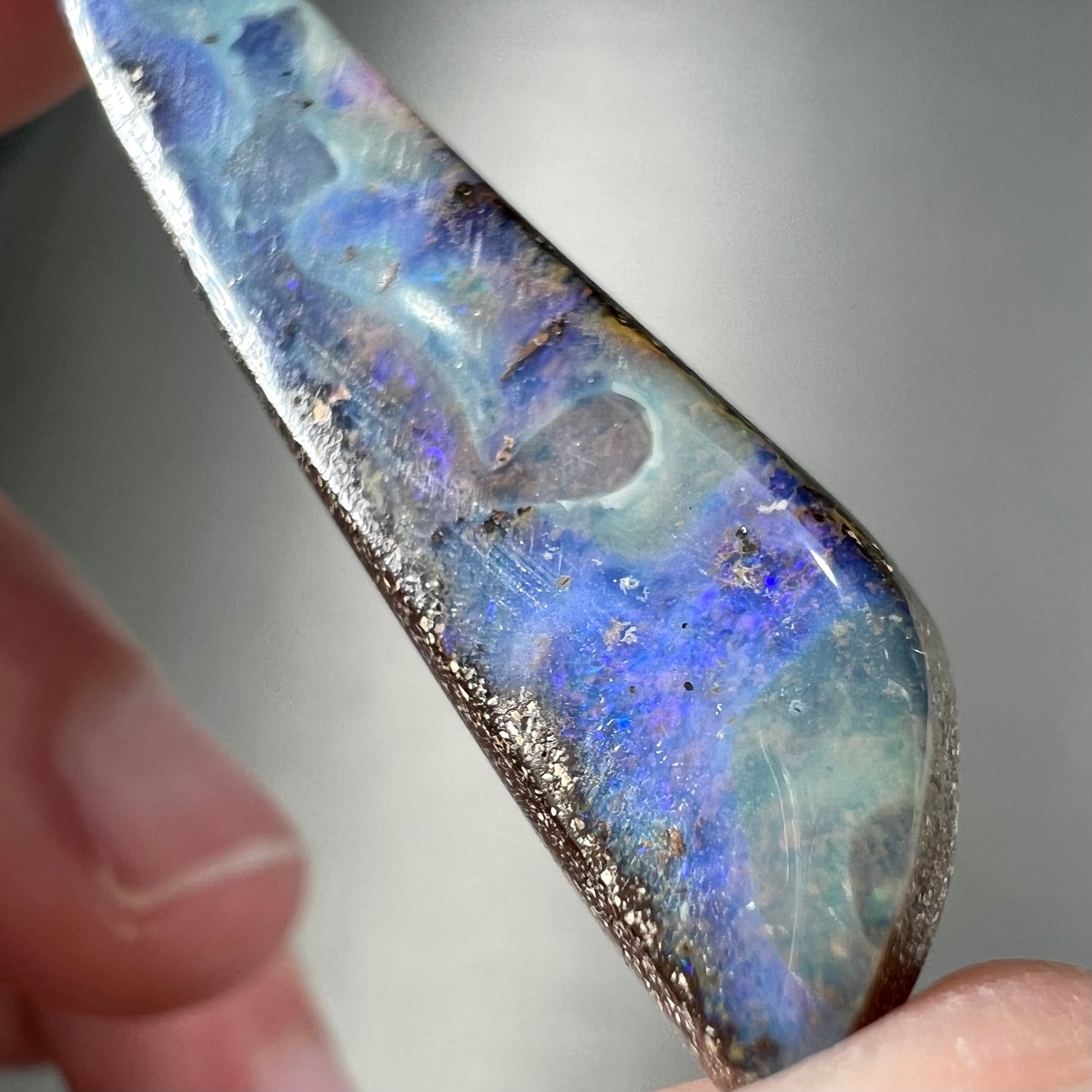 A loose, polished Quilpie boulder opal stone from Australia.  The stone is predominantly blue.