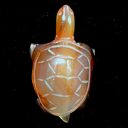 A stone turtle carved from orange carnelian agate.