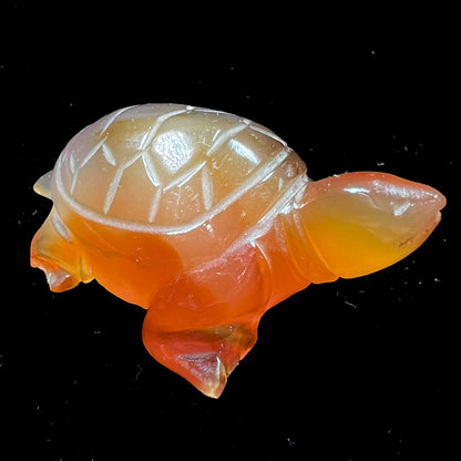 A stone turtle carved from orange carnelian agate.