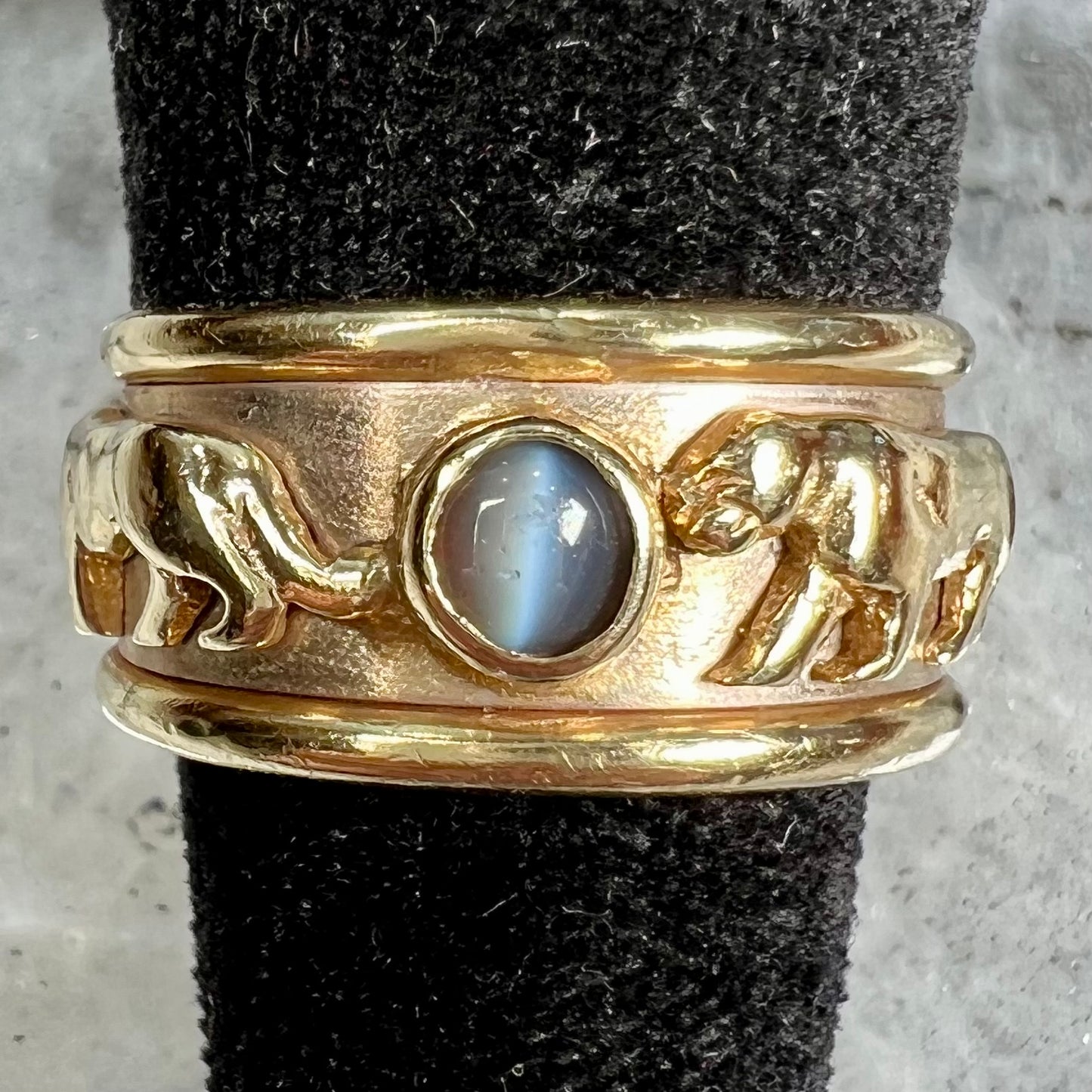 Men's gold ring set with three cabochon cut cat's eye alexandrite stones and panther designs.