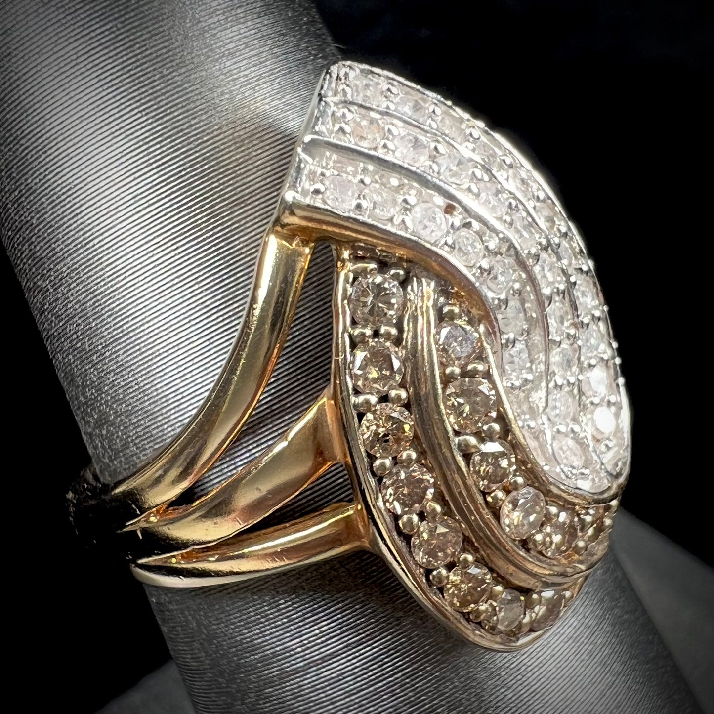 A ladies' 10 karat yellow gold split shank ring pave set with white and champagne colored diamonds.