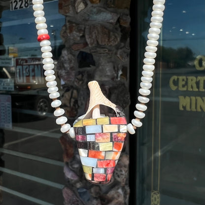 A seashell necklace that has been inlaid with spiny oyster and mother of pearl shell on a pearl bead necklace by Charlene Reano.