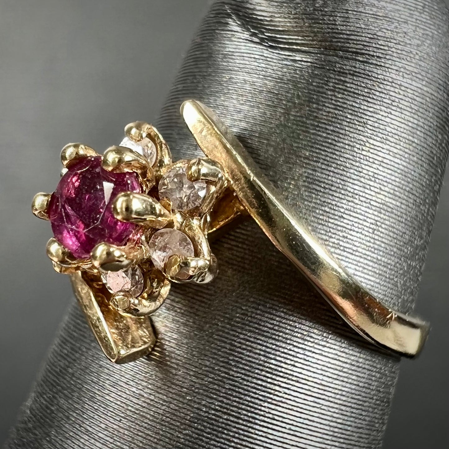 Custom twisted shank ruby and diamond halo yellow gold ring.