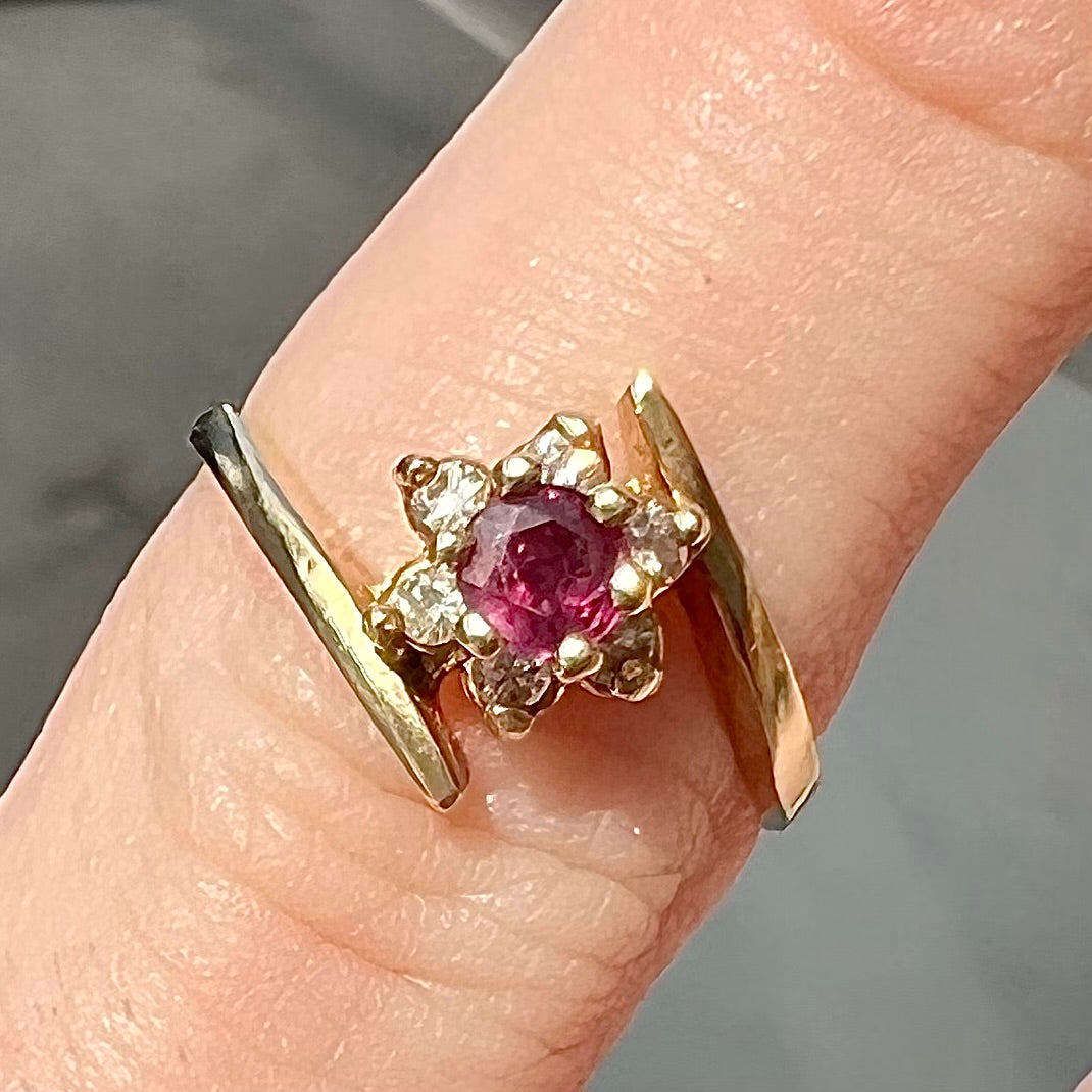 Custom twisted shank ruby and diamond halo yellow gold ring.