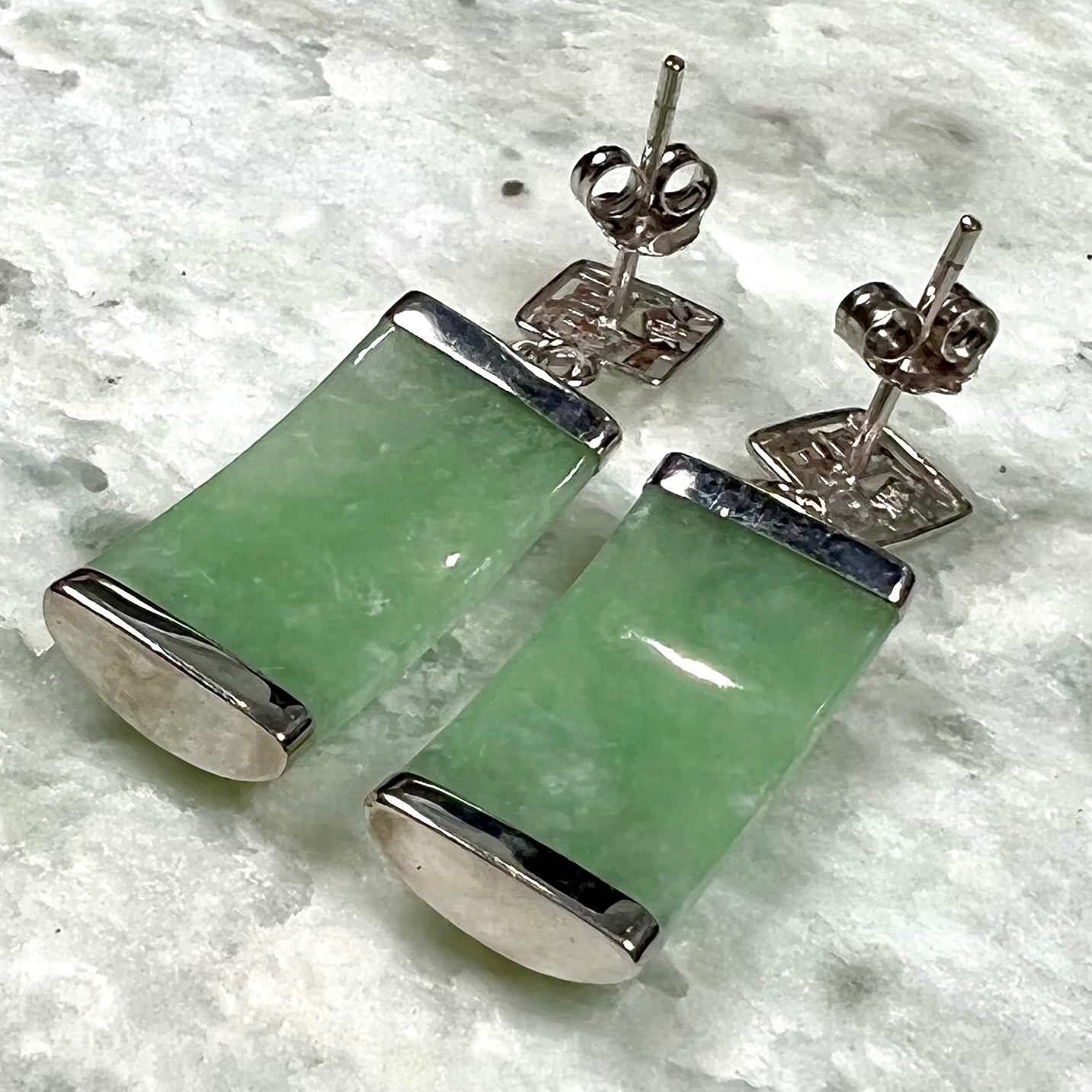 A pair of white gold jadeite dangle earrings with Chinese characters.