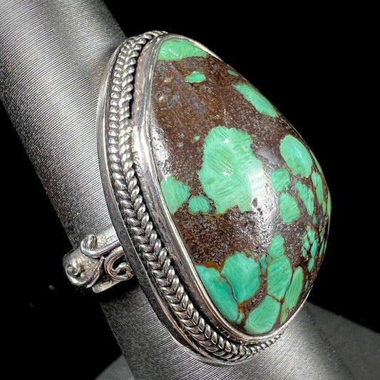 A sterling silver ring bezel set with a green spotted turquoise stone from Carico Lake, Nevada.