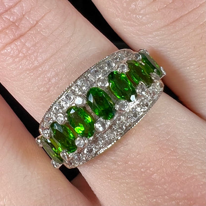 A ladies' two-tone white and yellow gold ring set withseven oval cut chrome diopside stones and cubic zirconia accents.