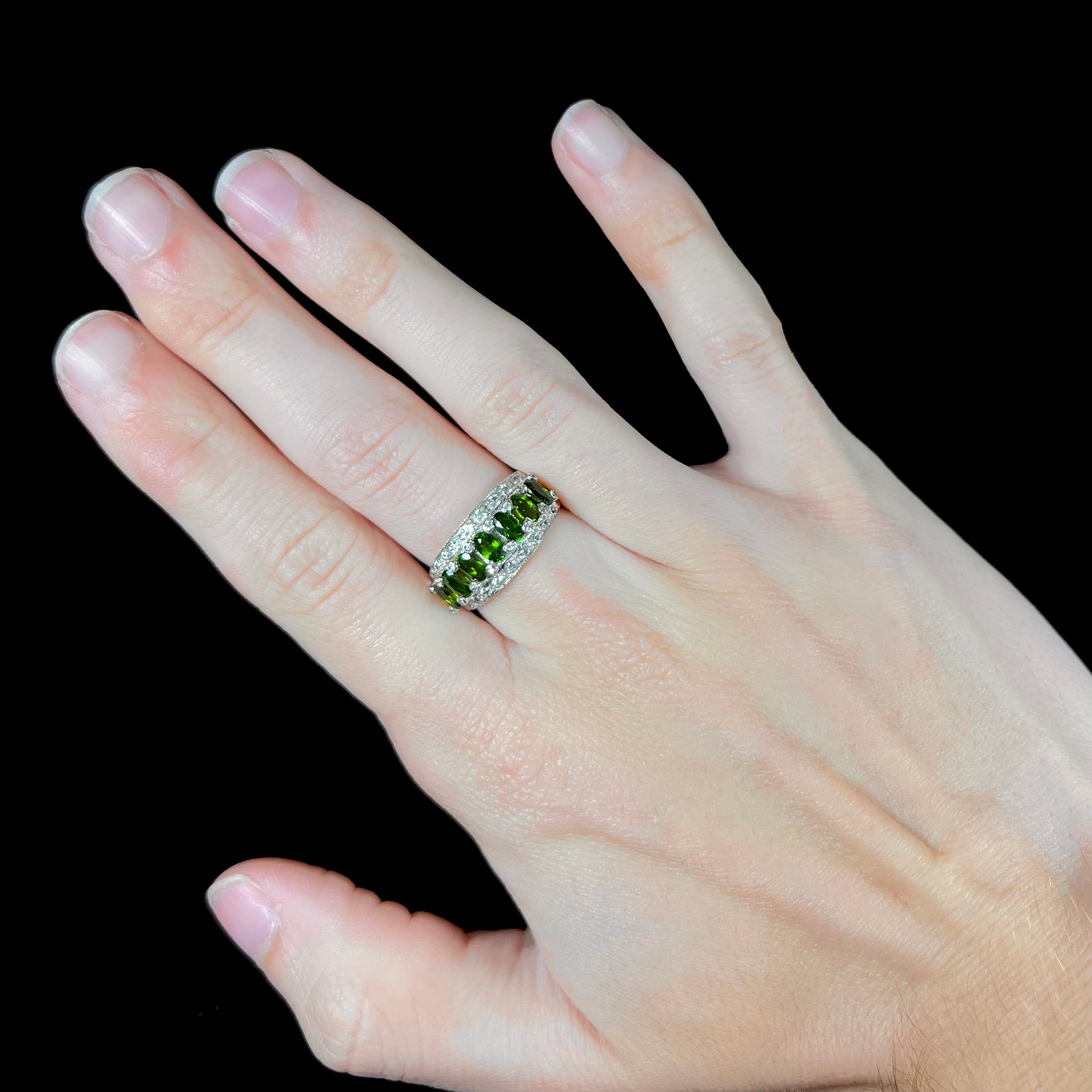 A ladies' two-tone white and yellow gold ring set withseven oval cut chrome diopside stones and cubic zirconia accents.