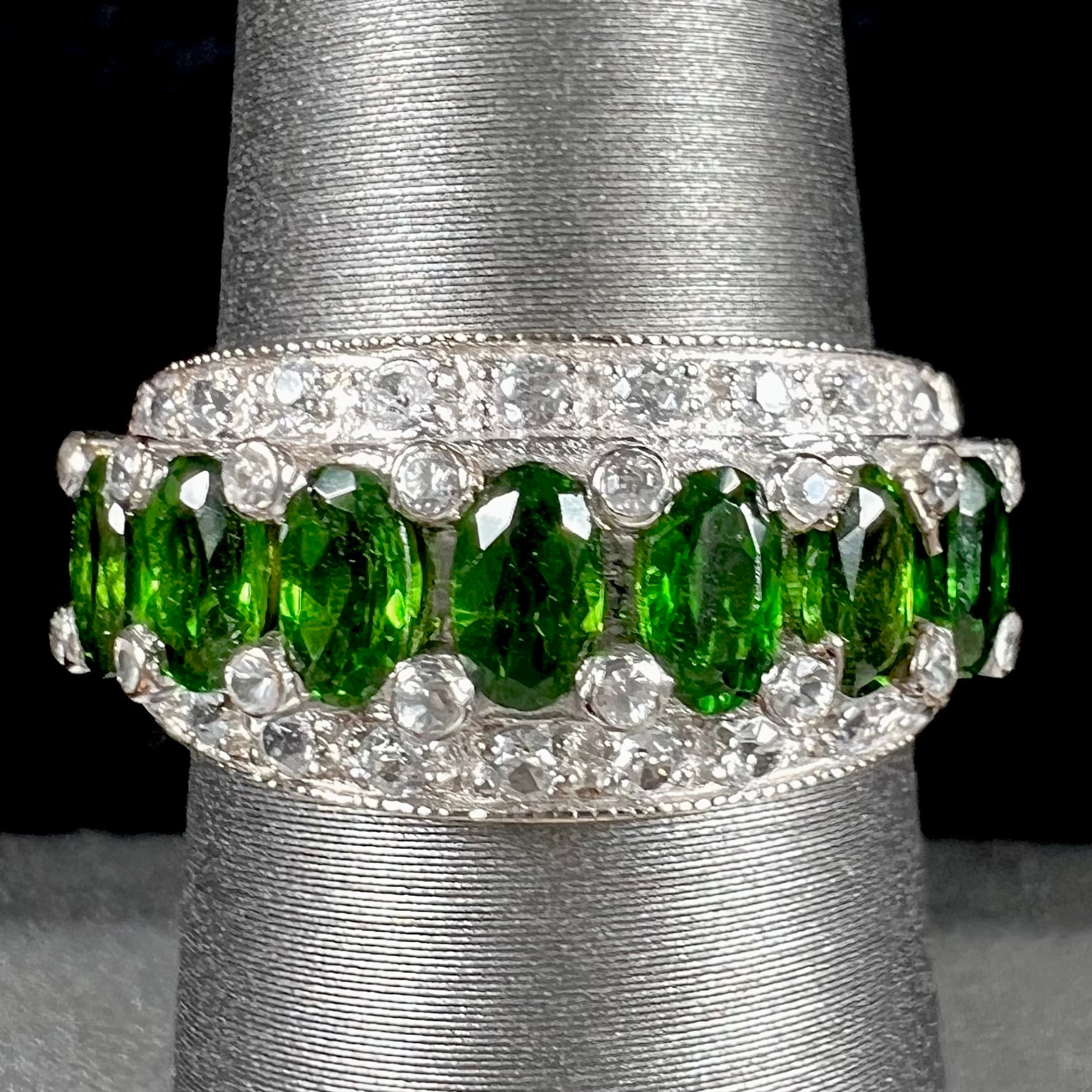A ladies' two-tone white and yellow gold ring set withseven oval cut chrome diopside stones and cubic zirconia accents.