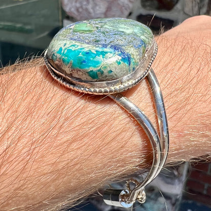 A handmade sterling silver cuff bracelet set with a single stone formed from variscite, chrysocolla, and azurite.