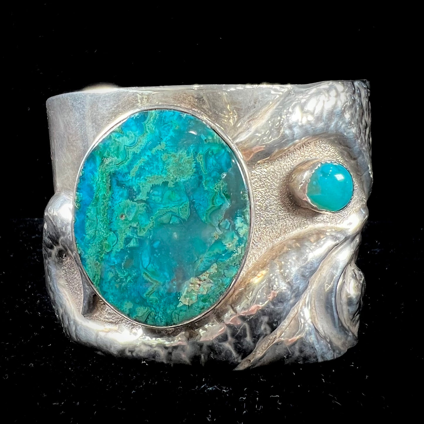 A men's sterling silver cuff bracelet set with two oval cut chrysocolla stones.