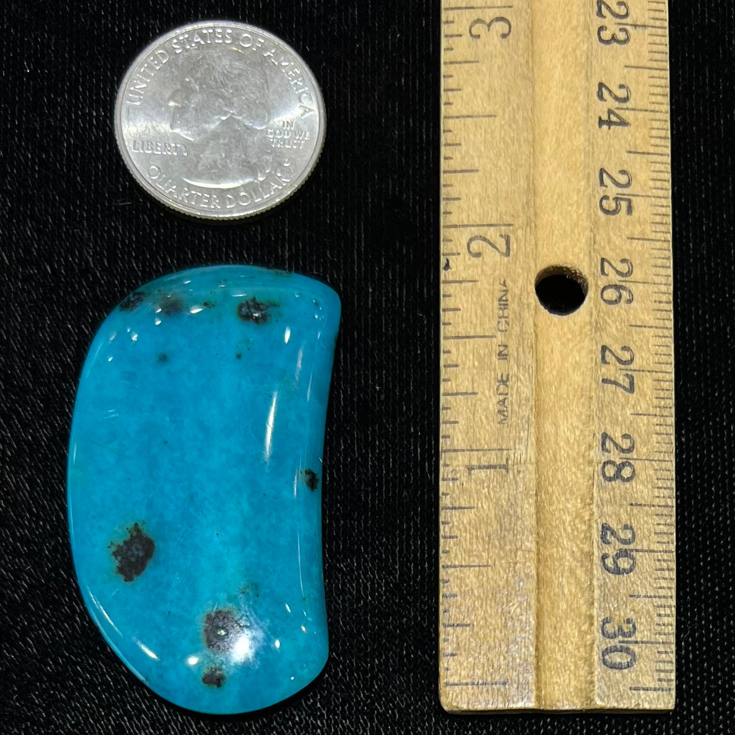 A loose, polished, spotted blue chrysocolla stone.