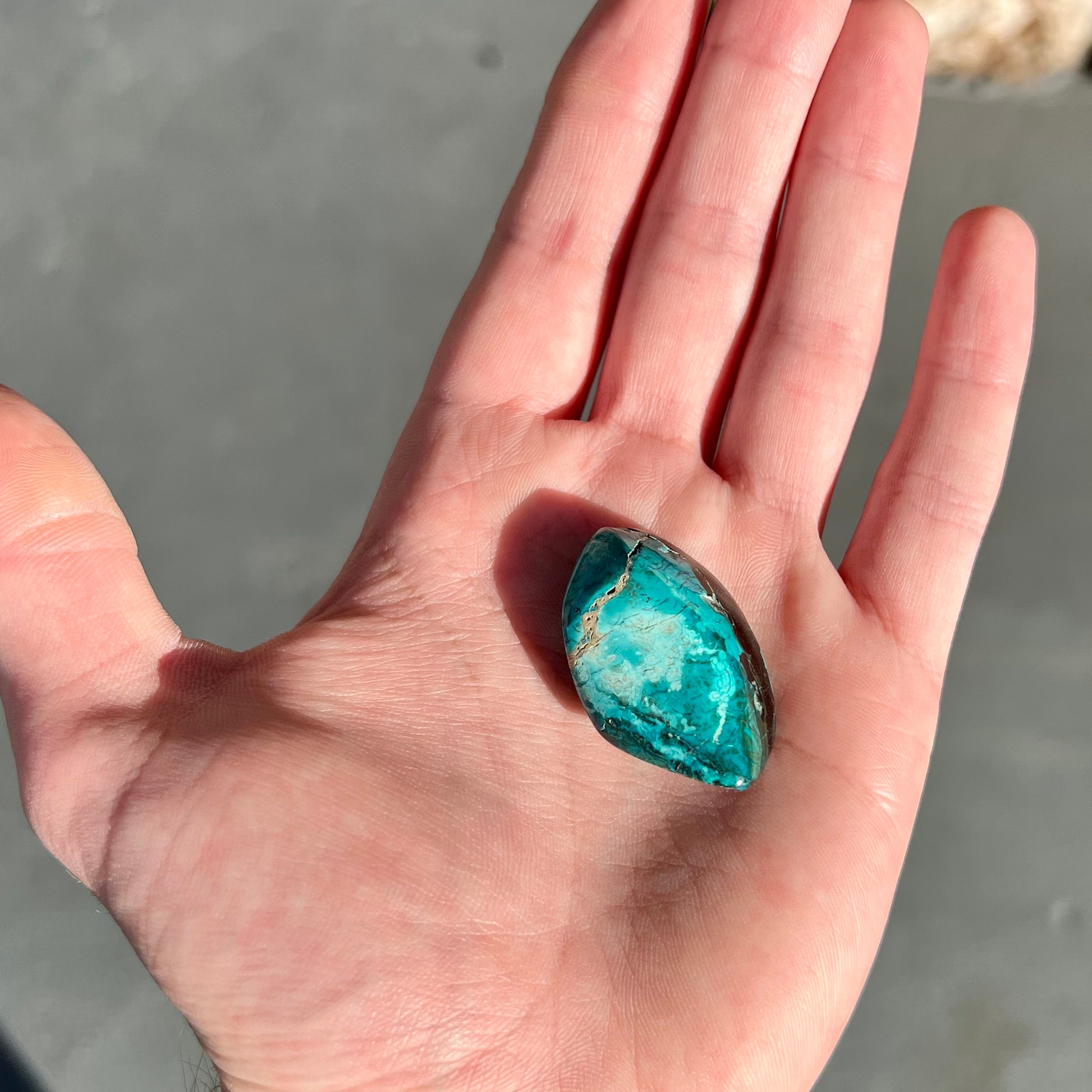 A loose chrysocolla stone with turquoise inclusions.