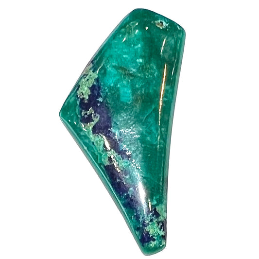 A loose triangular freeform cabochon cut green chrysocolla with blue azurite inclusions.