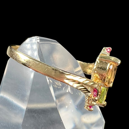 A gold twisted shank ring set with a marquise cut citrine, marquise cut peridot, and round cut ruby accents.