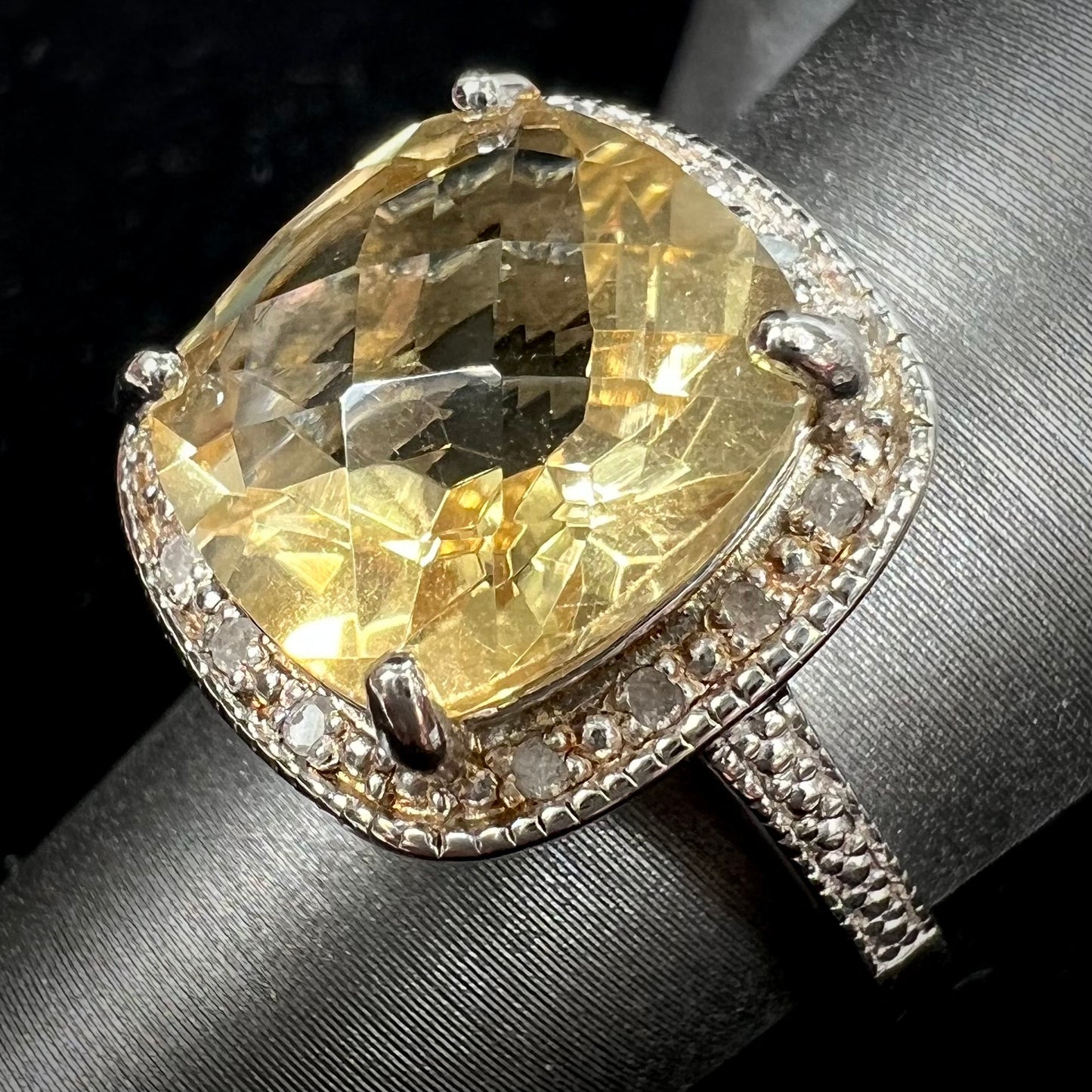 A silver cushion cut citrine and diamond halo ladies' ring.