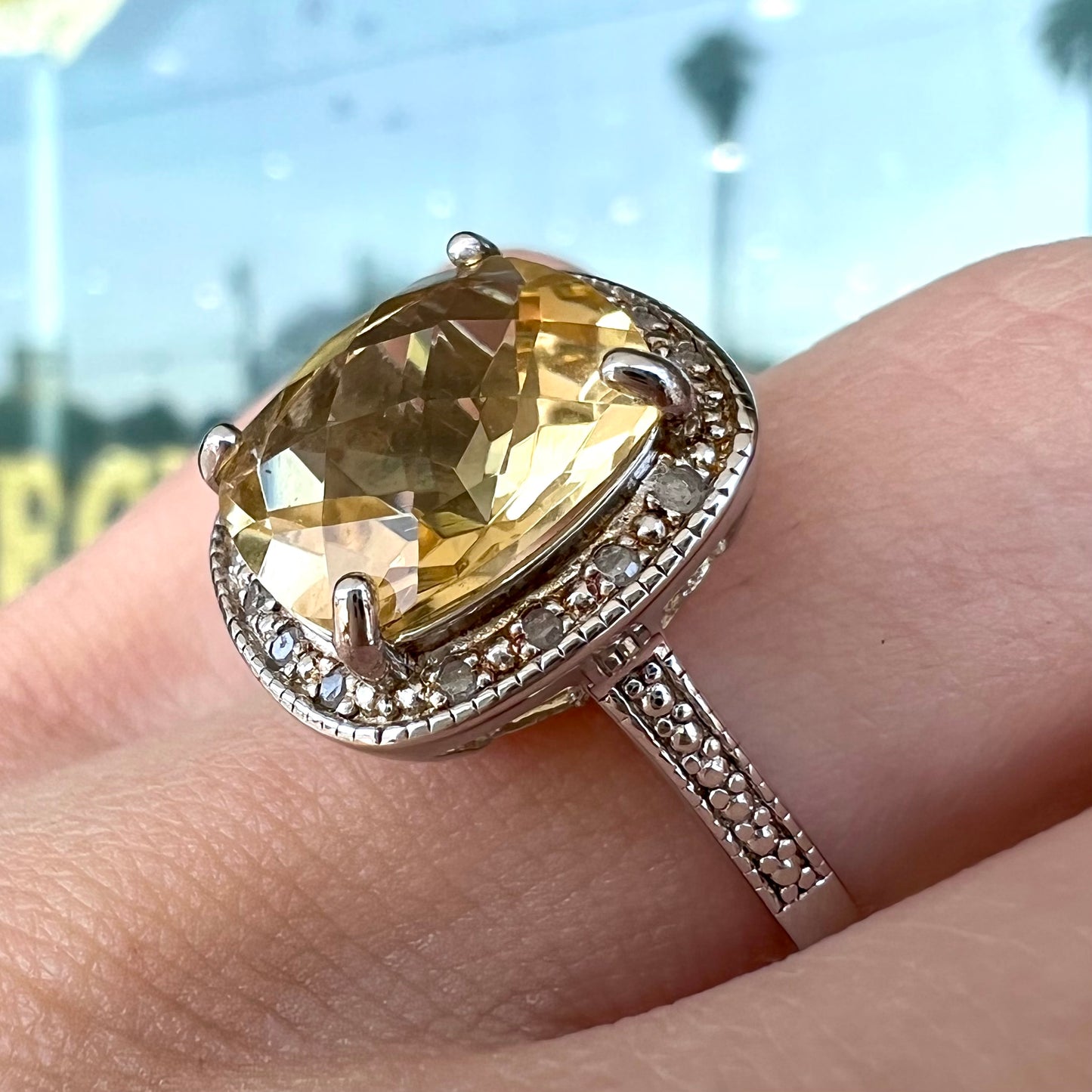 A silver cushion cut citrine and diamond halo ladies' ring.