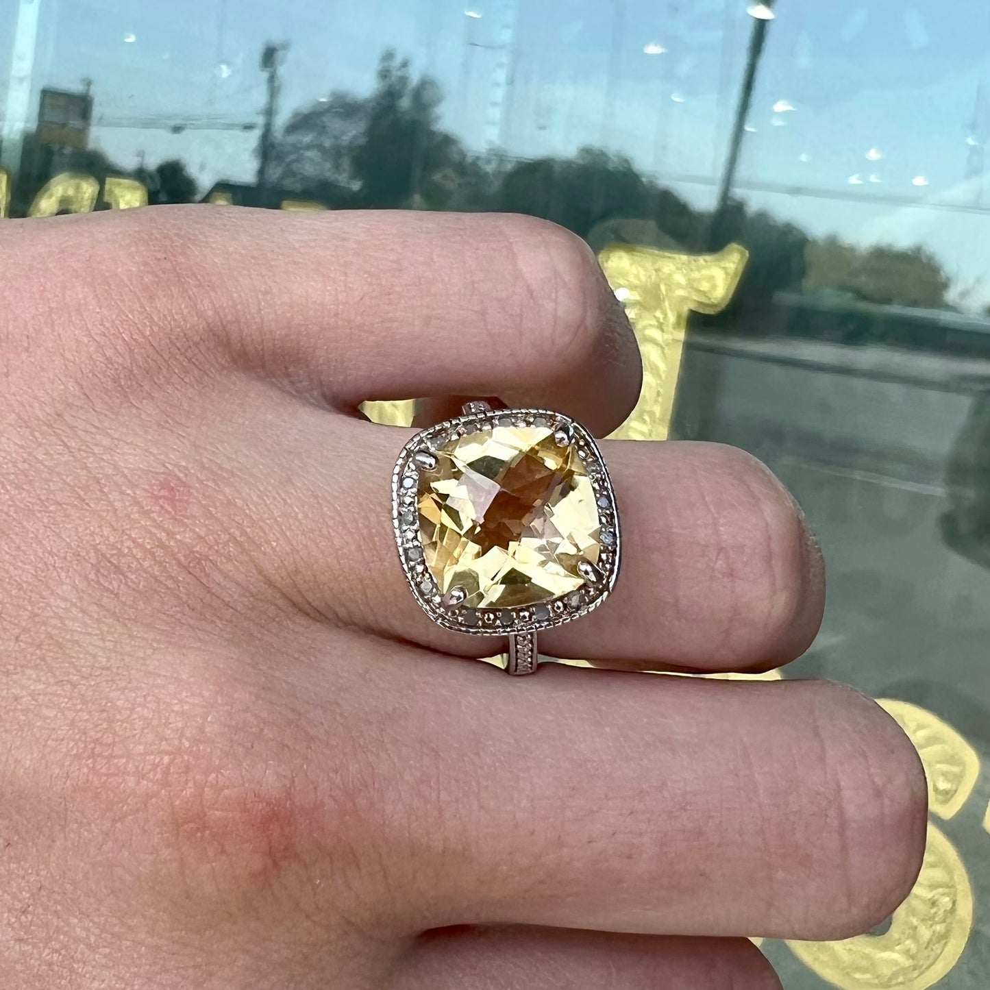 A silver cushion cut citrine and diamond halo ladies' ring.