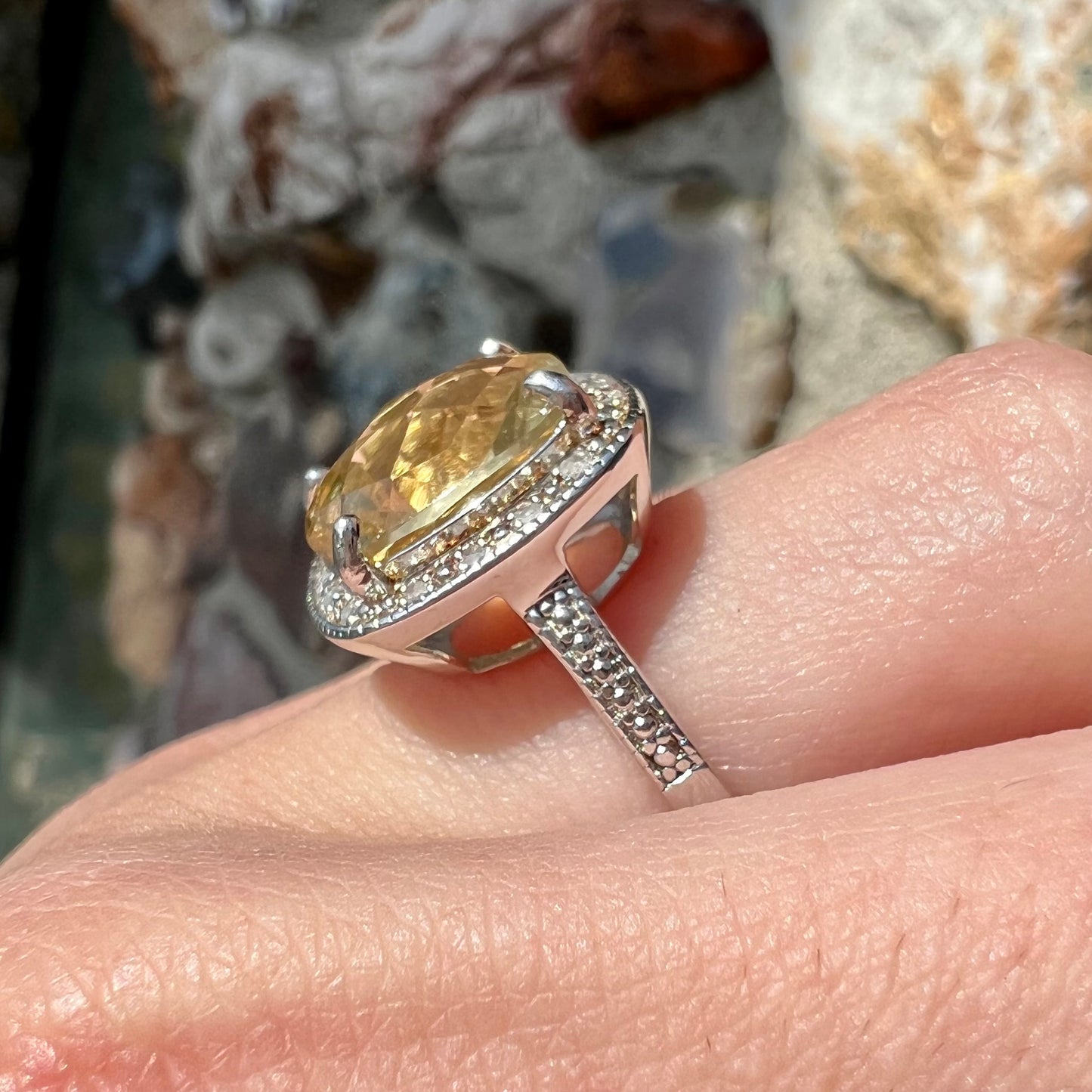 A silver cushion cut citrine and diamond halo ladies' ring.