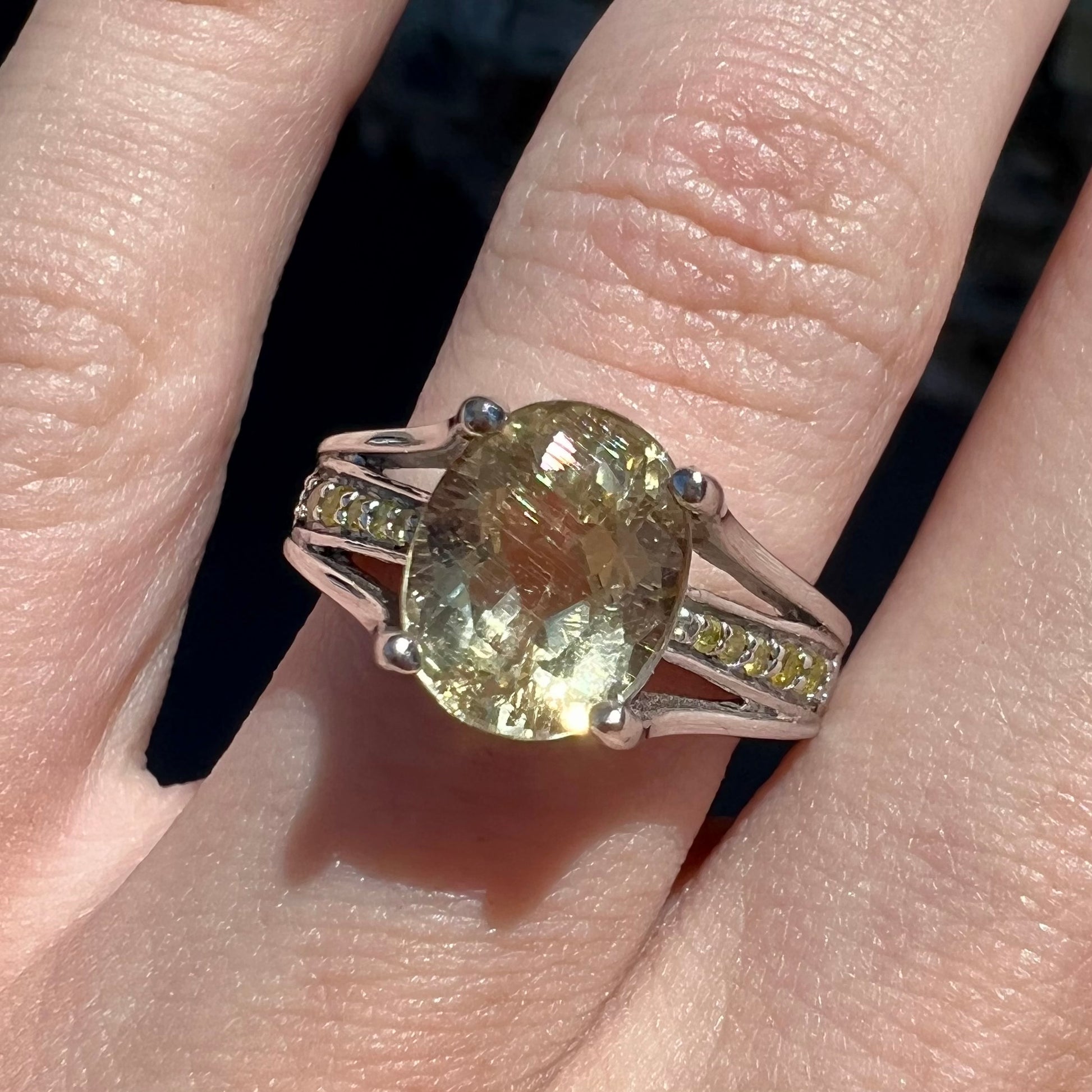 A sterling silver oval cut citrine ring set with canary yellow diamond accents.
