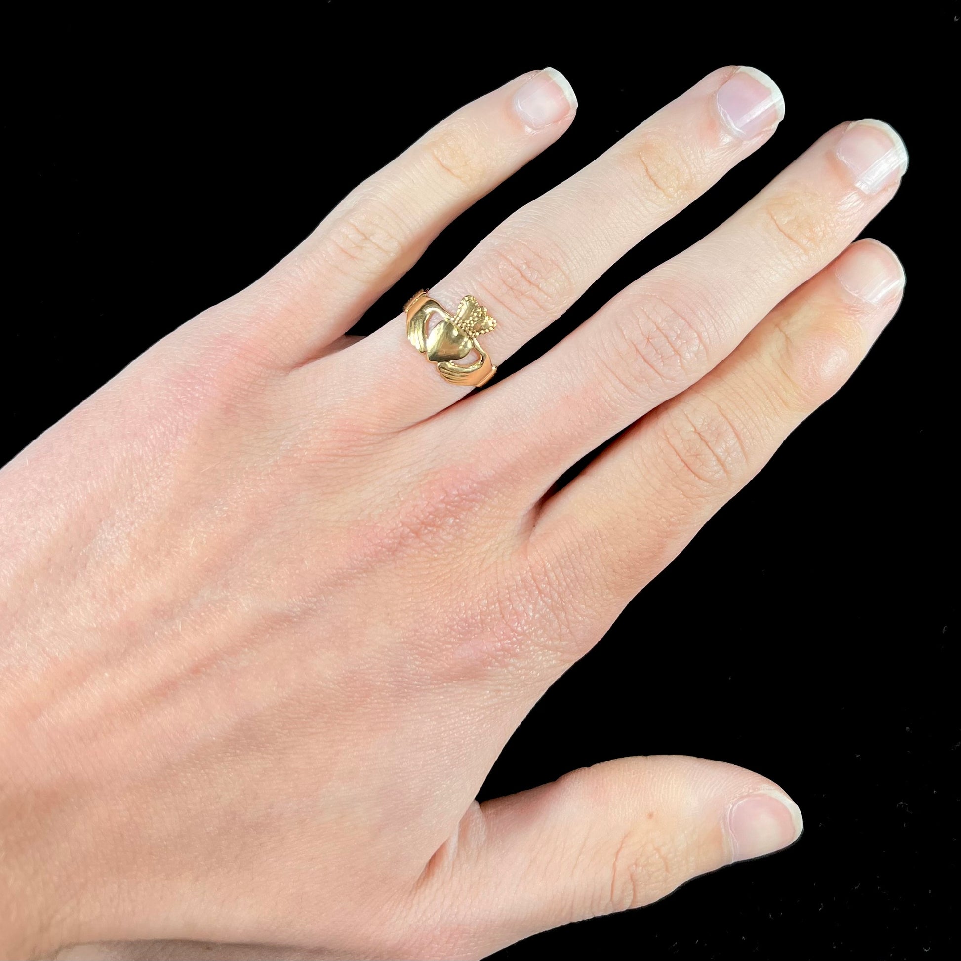 A ladies' 14 karat yellow gold Irish claddagh ring stamped with the maker's hallmarks.