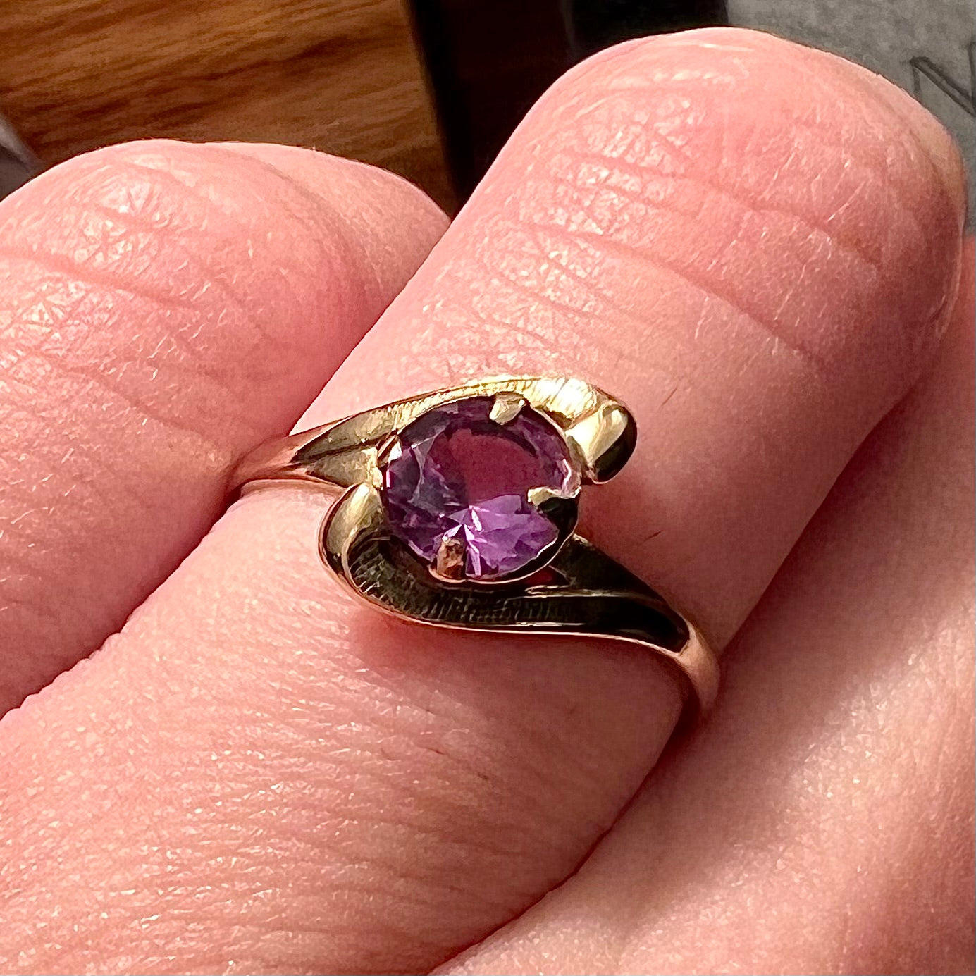 A vintage 1960's yellow gold ring set with a round synthetic purple alexandrite.  The prongs are worn.