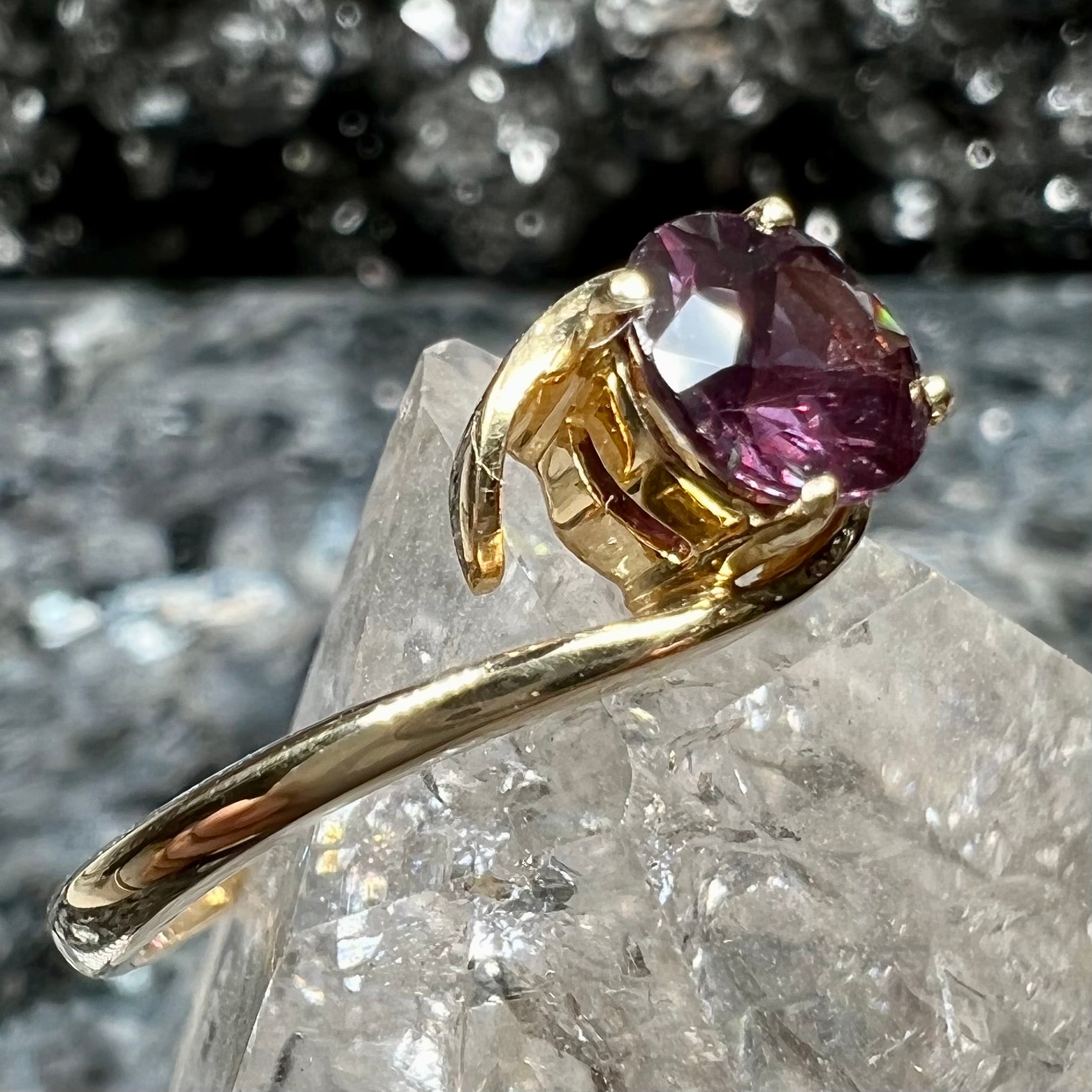 A yellow gold solitaire engagement ring set with a faceted oval cut color change garnet stone.