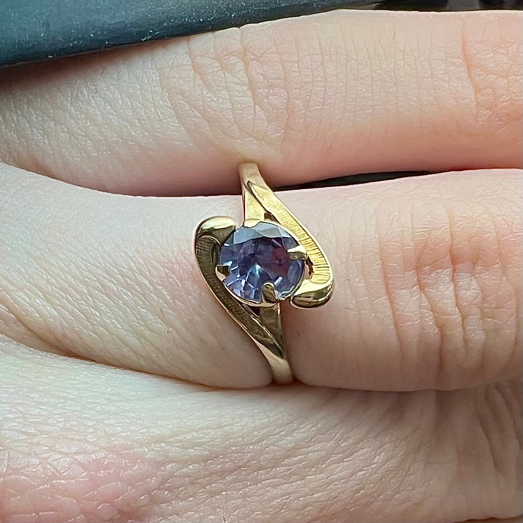 A vintage 1960's yellow gold ring set with a round synthetic purple alexandrite.  The prongs are worn.