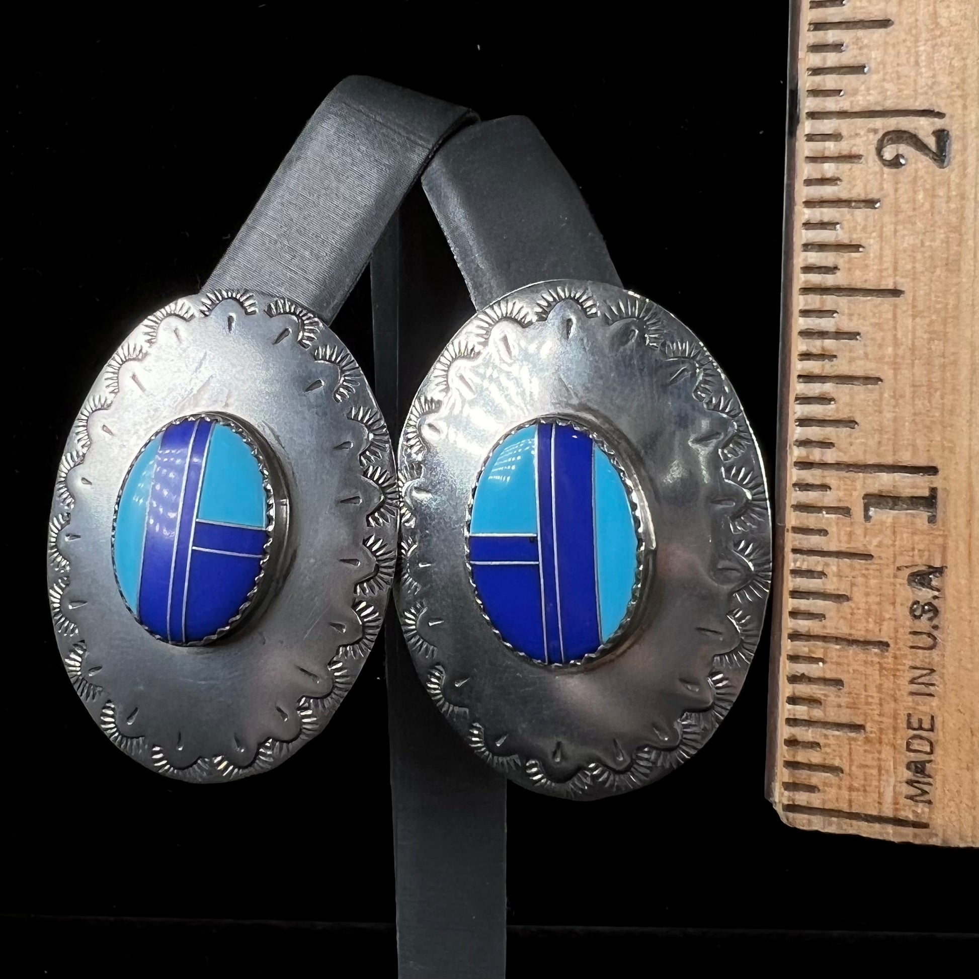 A pair of sterling silver concho earrings set with lapis lazuli and turquoise stone inlay.