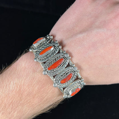 A sterling silver cuff bracelet set with polished coral branches handmade by Navajo artist, Delbert Chatter.