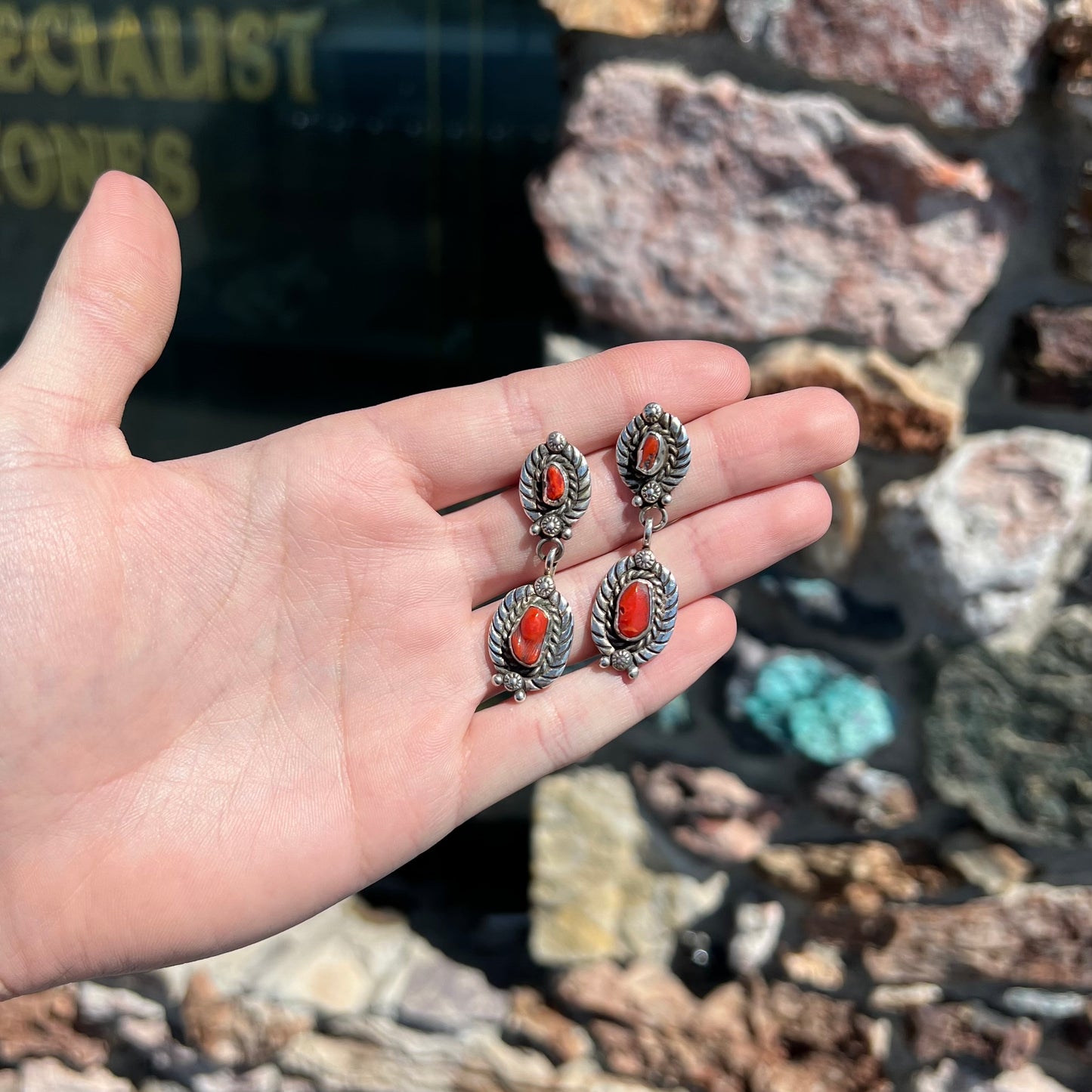 A pair of vintage coral branch dangle earrings handmade by Navajo artist, Delbert Chatter.