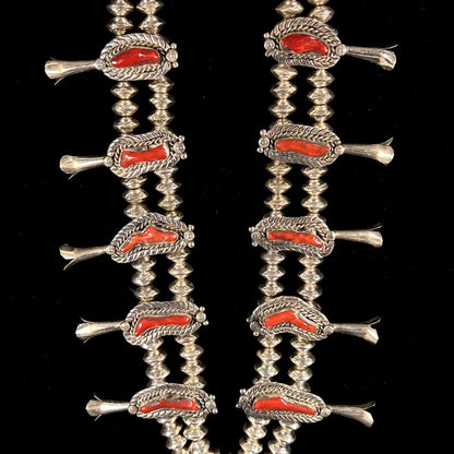 A Navajo style squash blossom necklace set with red coral branches, handmade by artist Delbert Chatter.