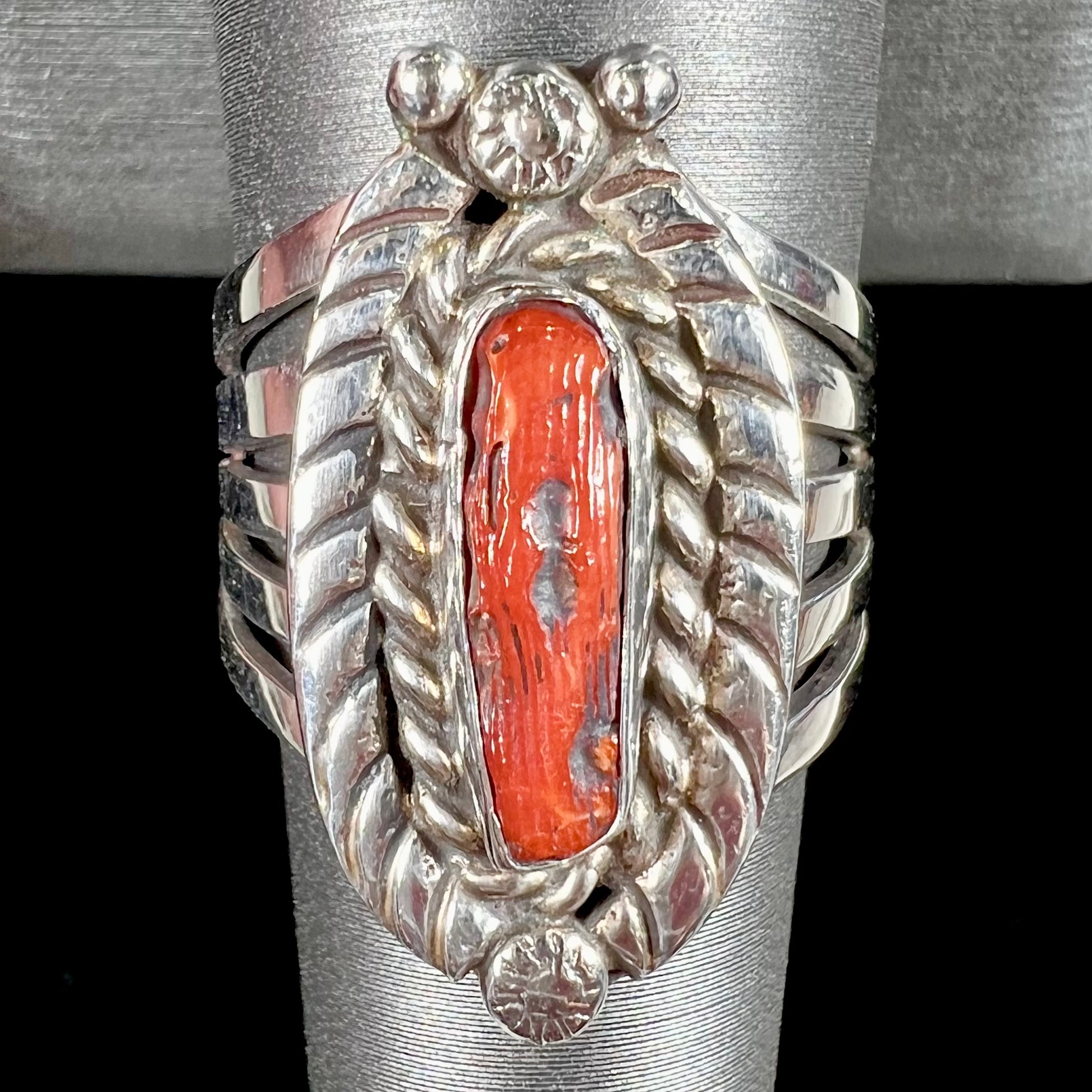 A sterling silver ring set with a polished red coral branch handmade by Navajo artist, Delbert Chatter.