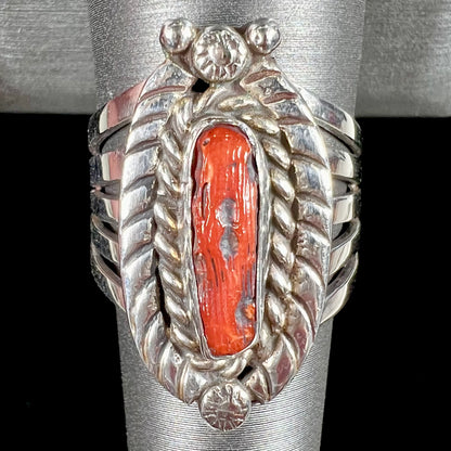 A sterling silver ring set with a polished red coral branch handmade by Navajo artist, Delbert Chatter.