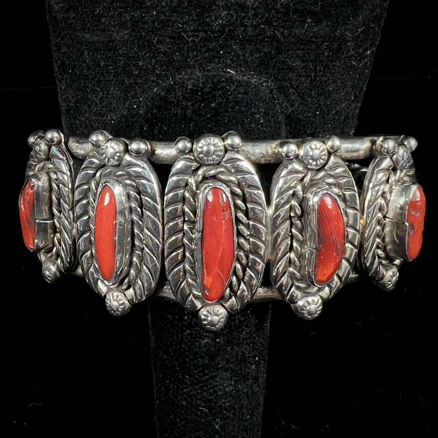 A sterling silver cuff bracelet set with polished coral branches handmade by Navajo artist, Delbert Chatter.