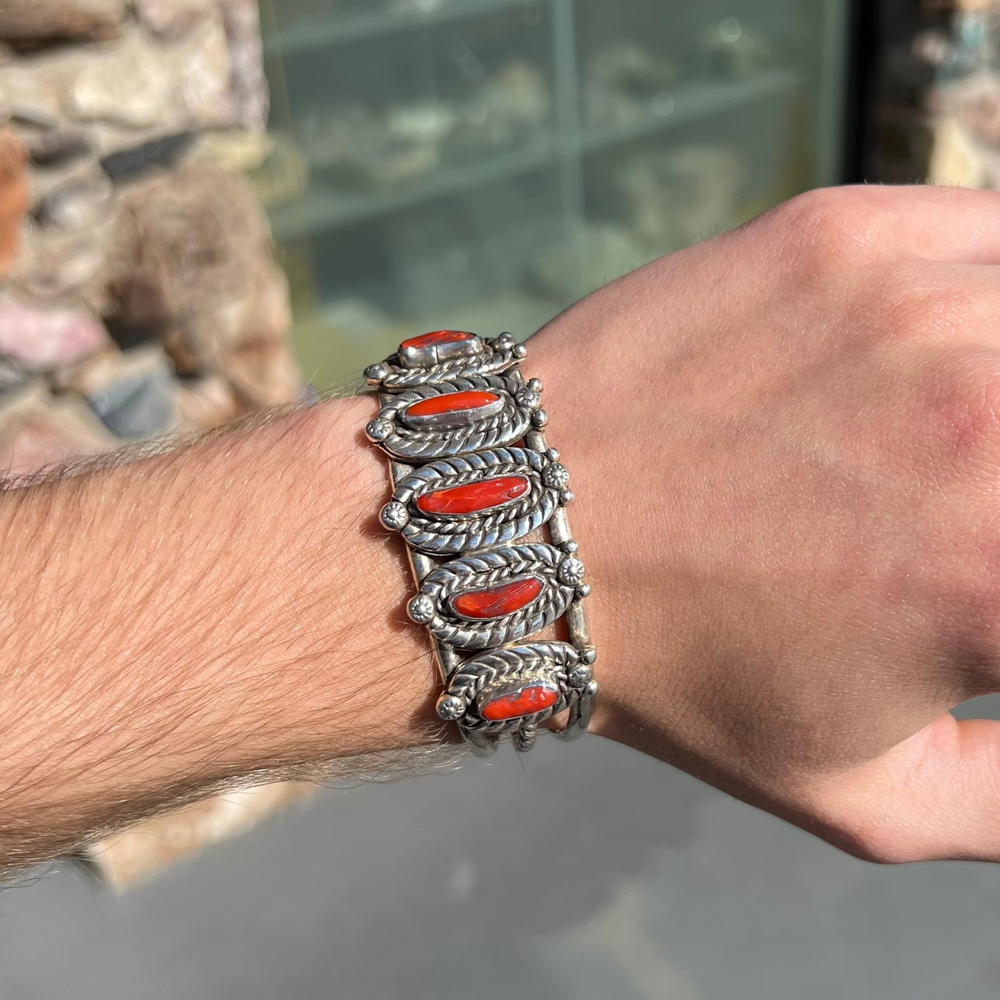 A sterling silver cuff bracelet set with polished coral branches handmade by Navajo artist, Delbert Chatter.