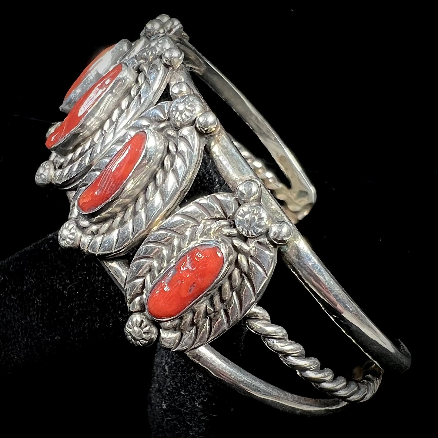 A sterling silver cuff bracelet set with polished coral branches handmade by Navajo artist, Delbert Chatter.