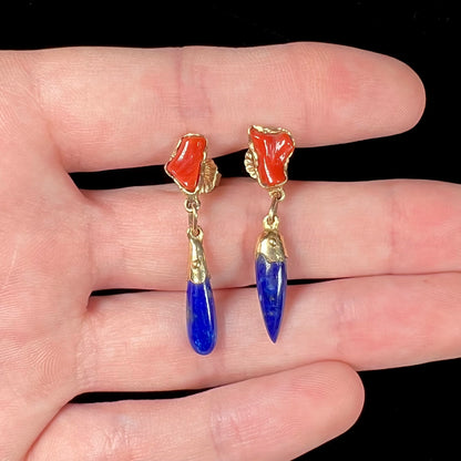 A pair of Navajo-handmade yellow gold dangle earrings set with lapis lazuli and polished coral branches.