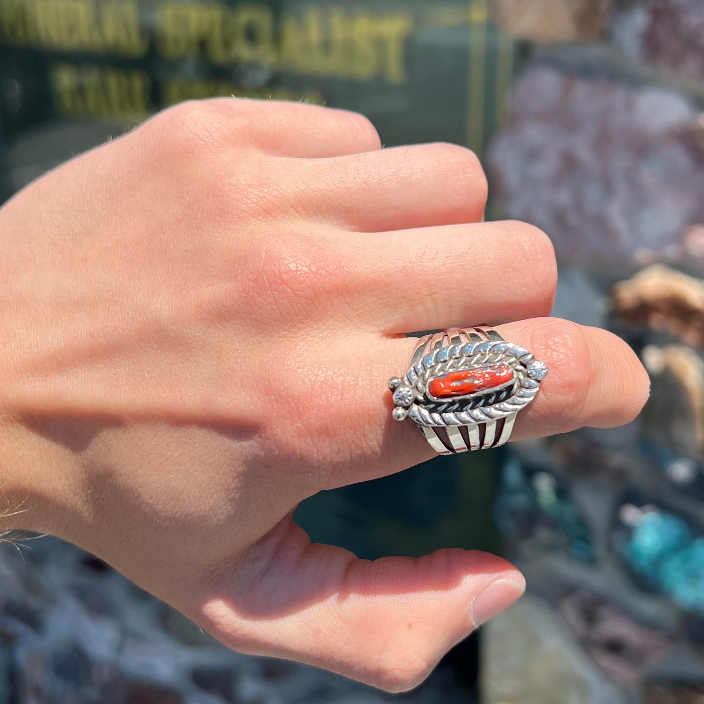 A sterling silver ring set with a polished red coral branch handmade by Navajo artist, Delbert Chatter.